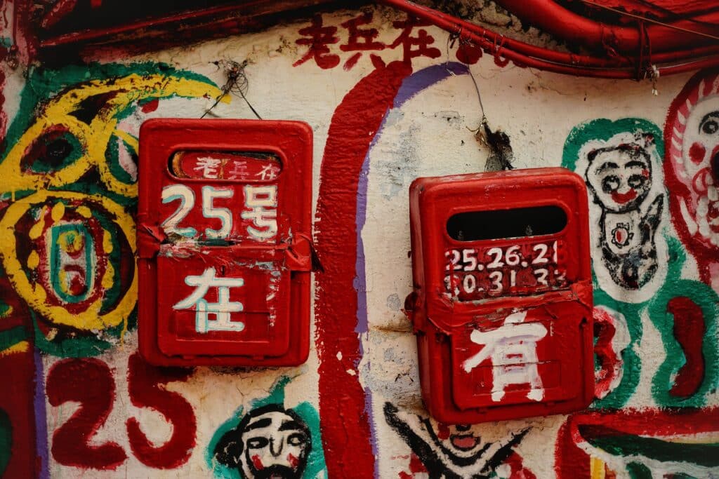 red boxes with numbers and chinese characters on wall with graffiti