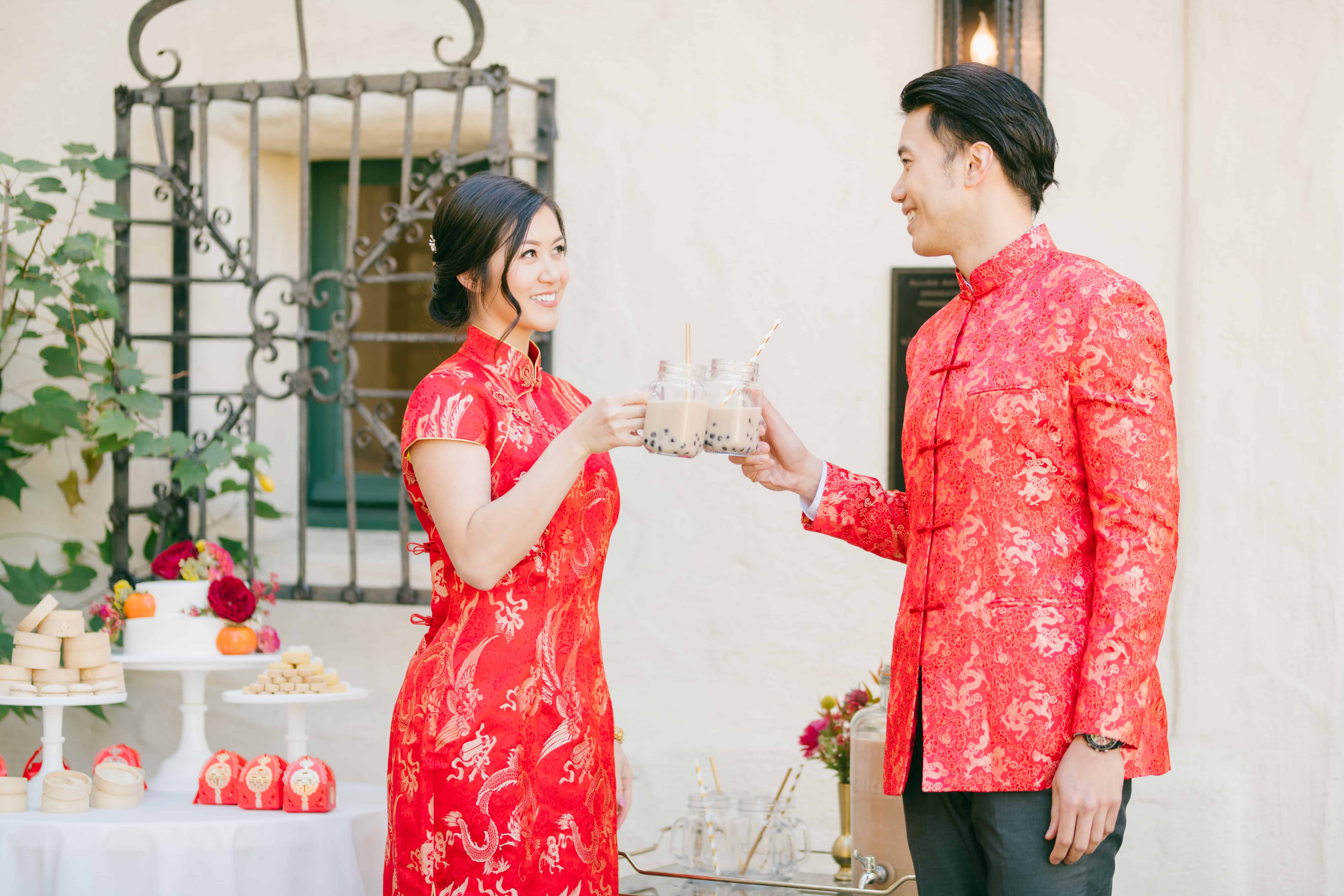 chinese couple in traditional red wedding outfits, drinking bubble tea