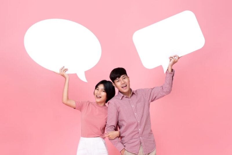 Lovely,smiling,young,asian,couple,with,speech,bubbles,studio,shot