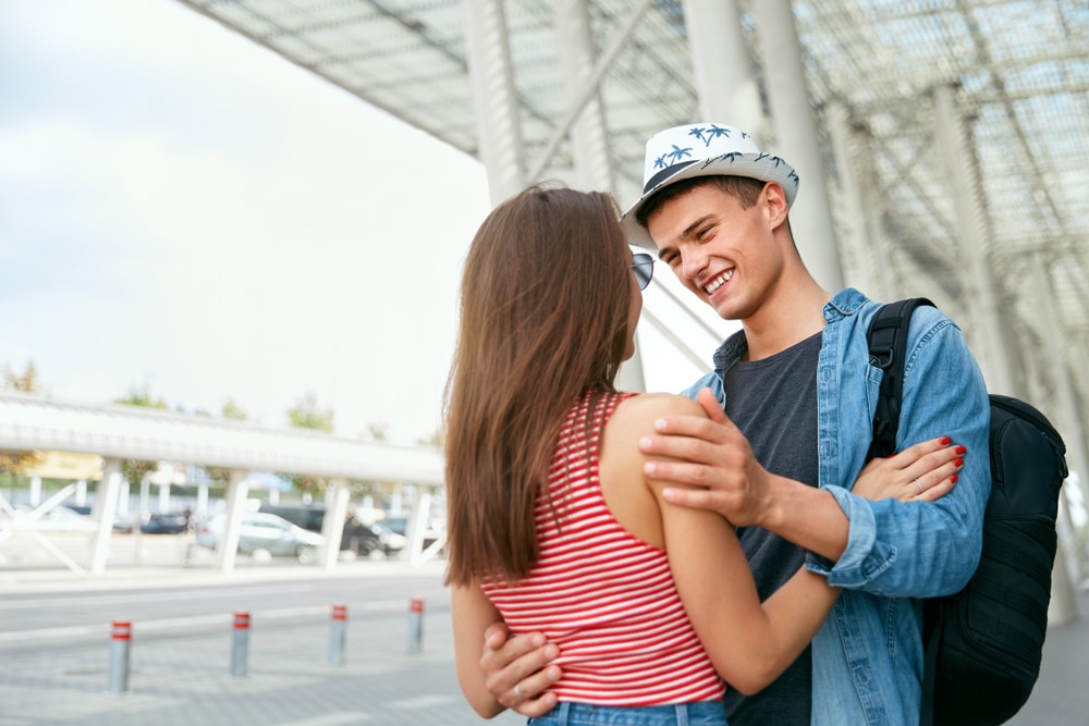 People-Hugging-In-Airport.-Loving-Young-Couple-Embracing-Say-Goodbye-Near-Departure-Terminal