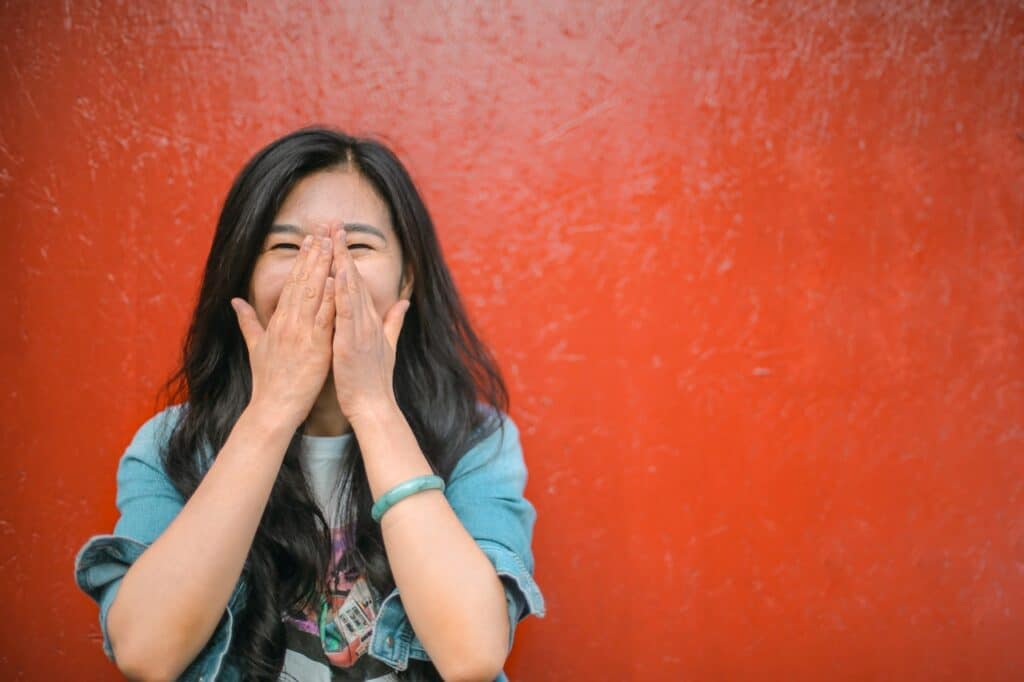 chinese girl covering her face and laughing