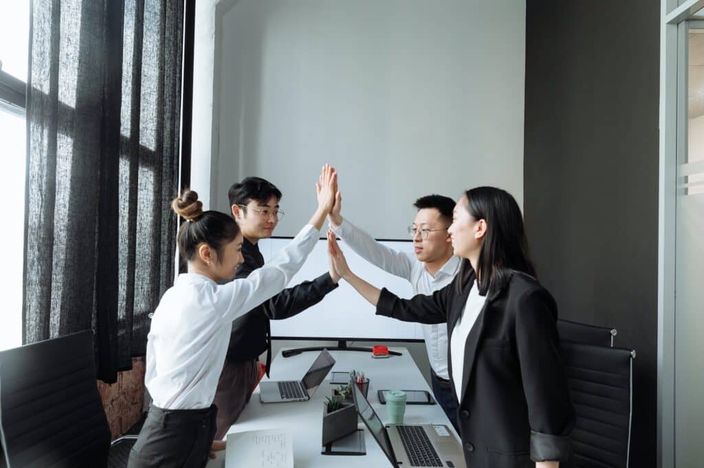 asian-coworkers-teammembers-highfiving-in-office