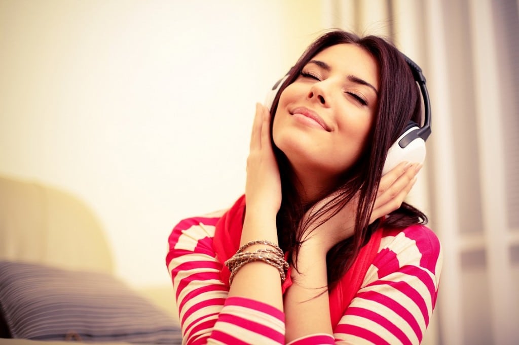 Woman in a red and white top listening to headphones