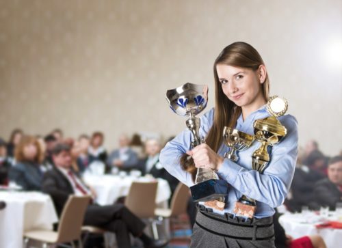 Woman holding several trophies