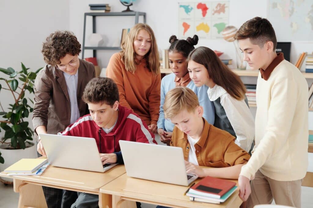 a group of students looking at the laptops
