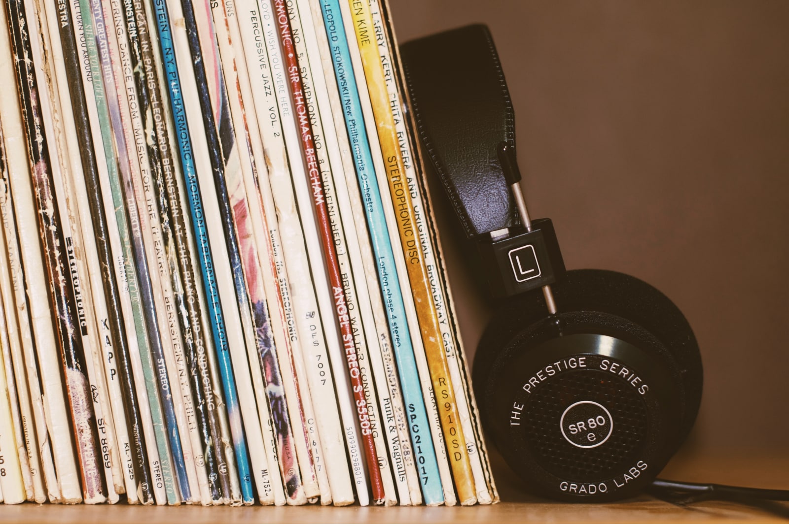 Headphones next to stack of records