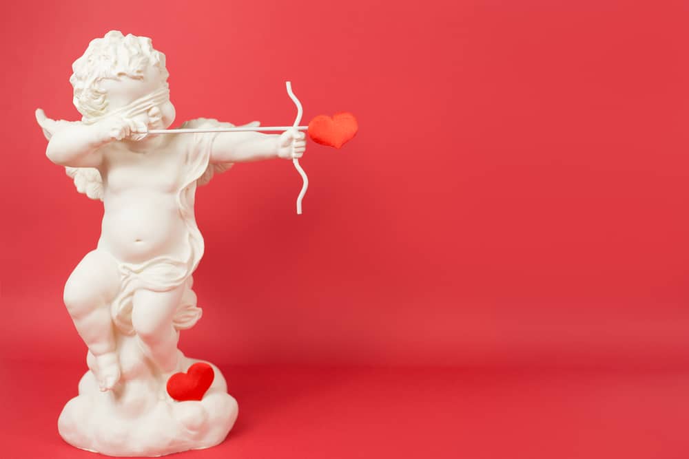 blindfolded cupid statue about to shoot an arrow for valentine's