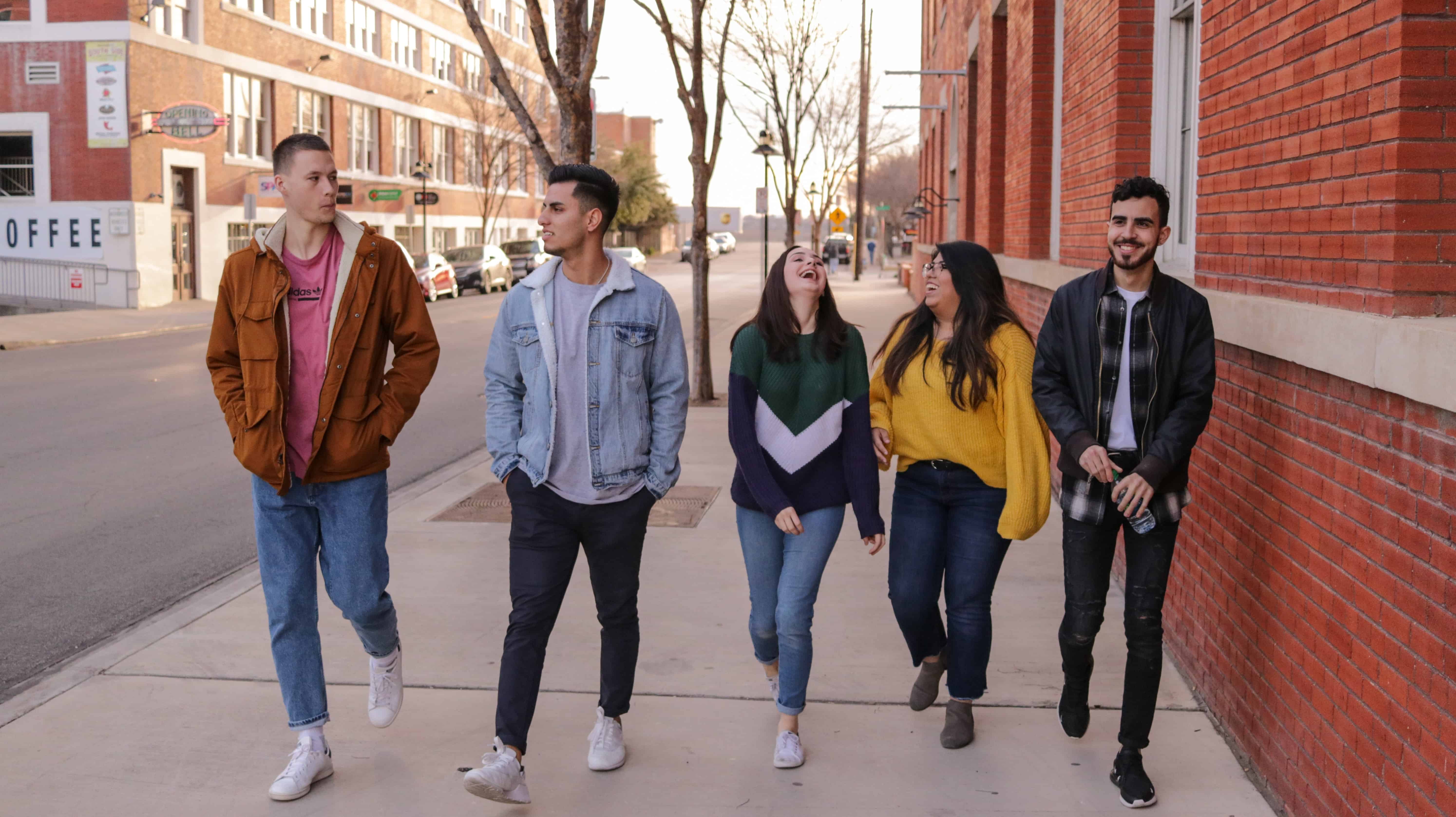 A group of students walks and talks on campus