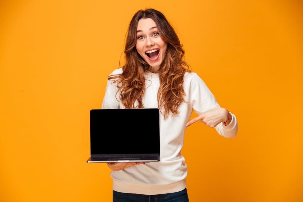 Surprised woman with laptop in hand