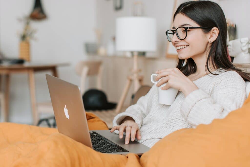 Girl smiling with coffee and laptop