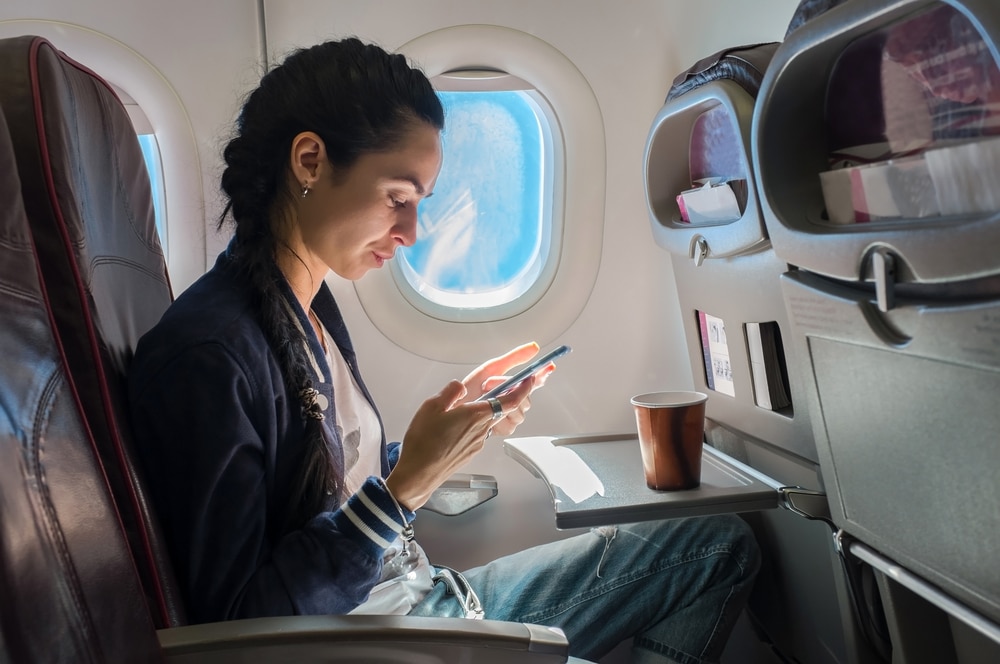 Woman In The Airplane With Phone