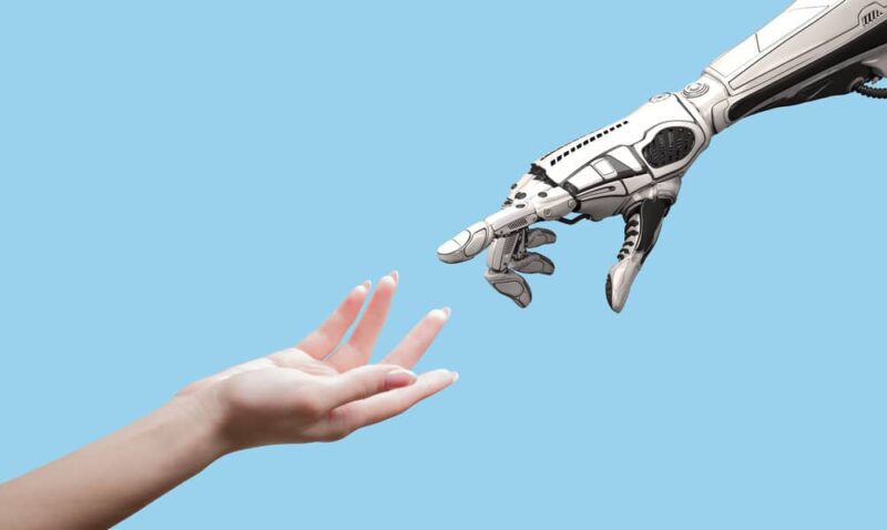 Female human hand and robot's as a symbol of connection between people and artificial intelligence technology