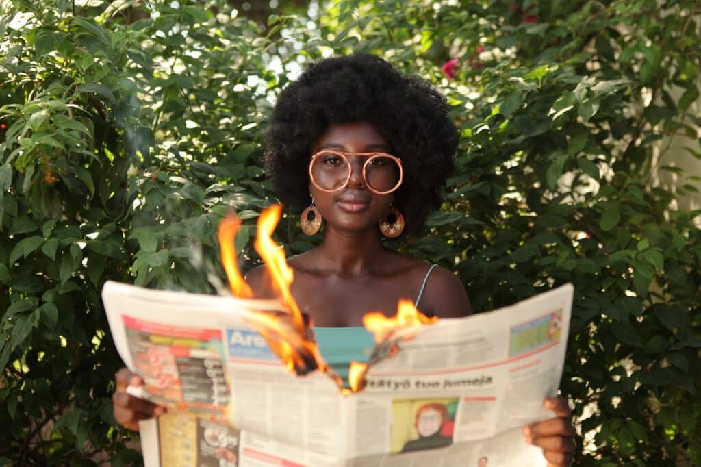 Girl with newspaper on fire