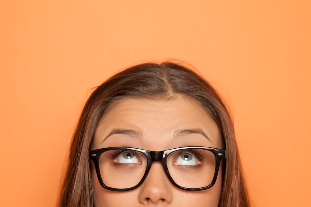 girl with glasses looking up