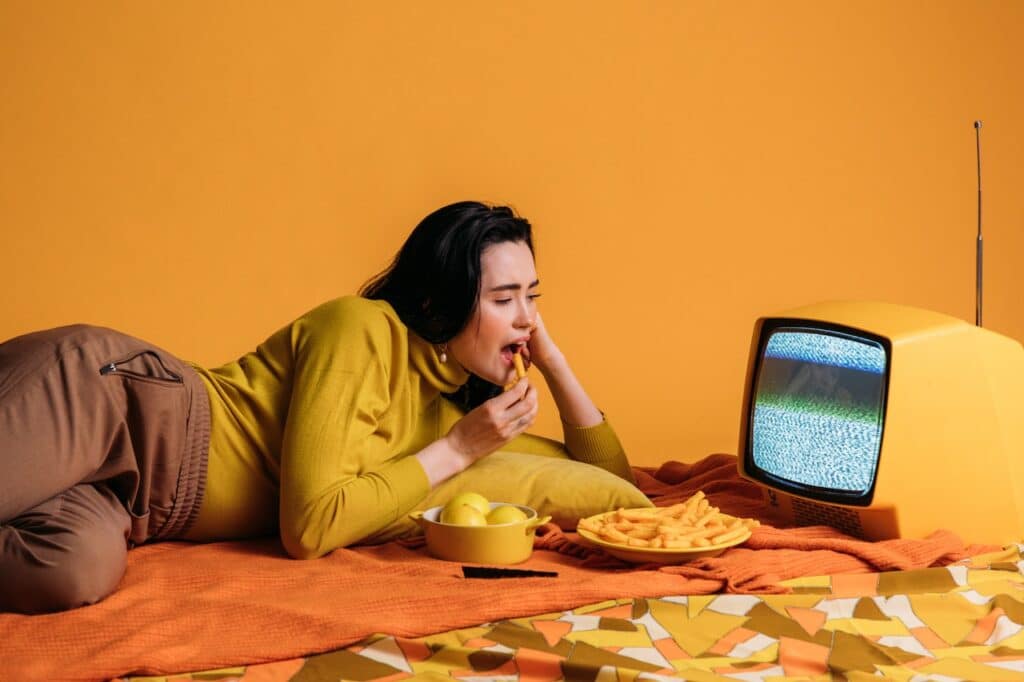Girl watching TV while eating snacks