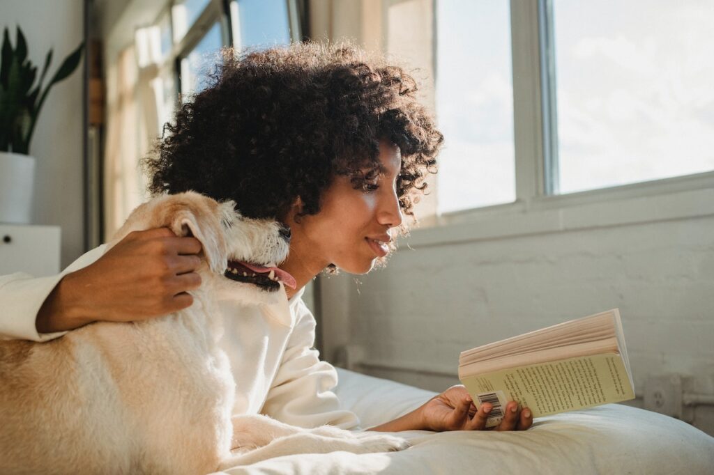 woman reading next to her dog