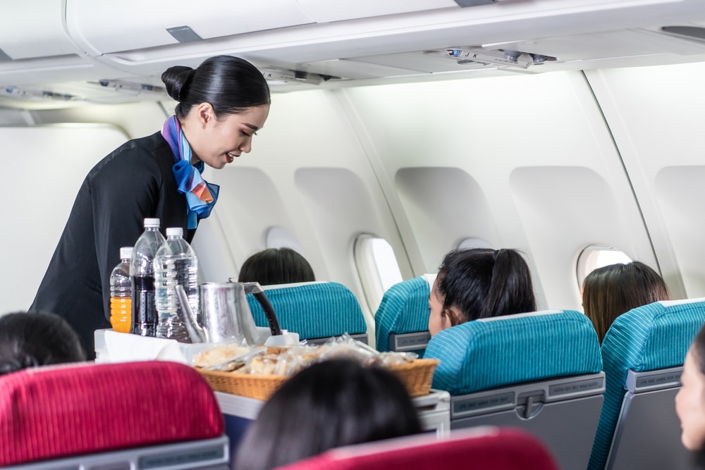 Flight attendant serving food and drink