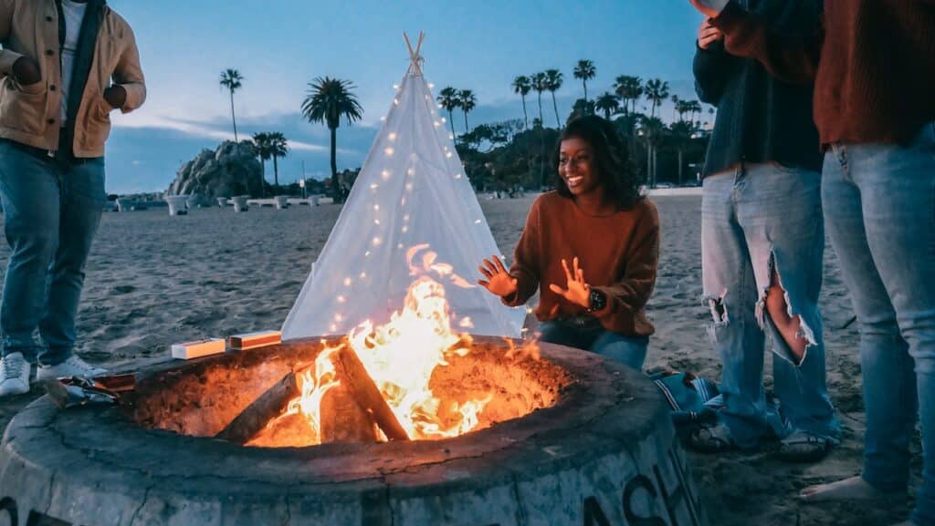 Friends next to a bonfire at the beach