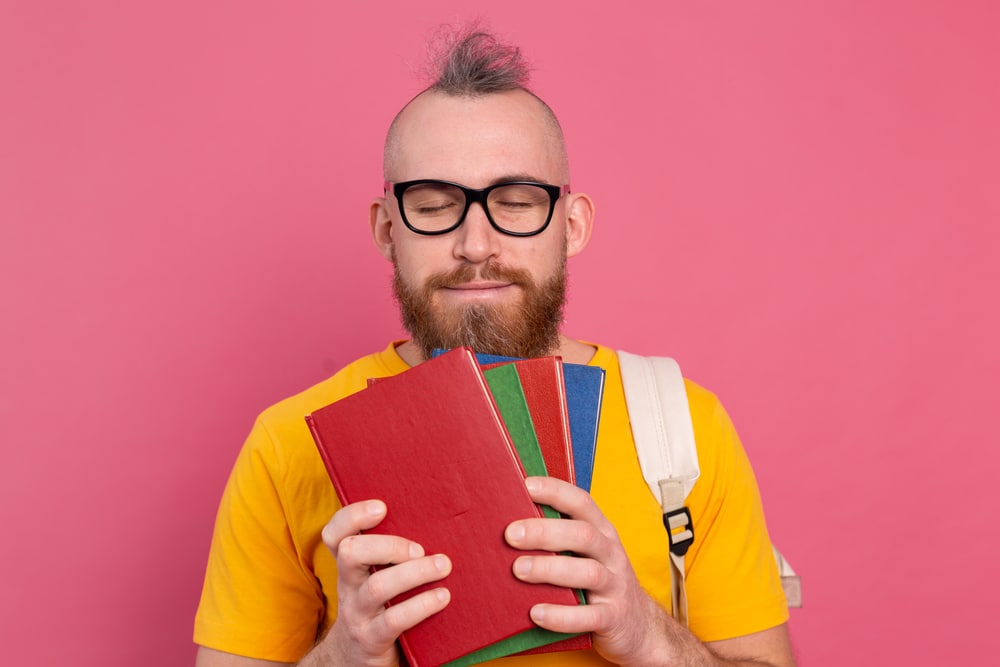 Man with eyes closed holding some books