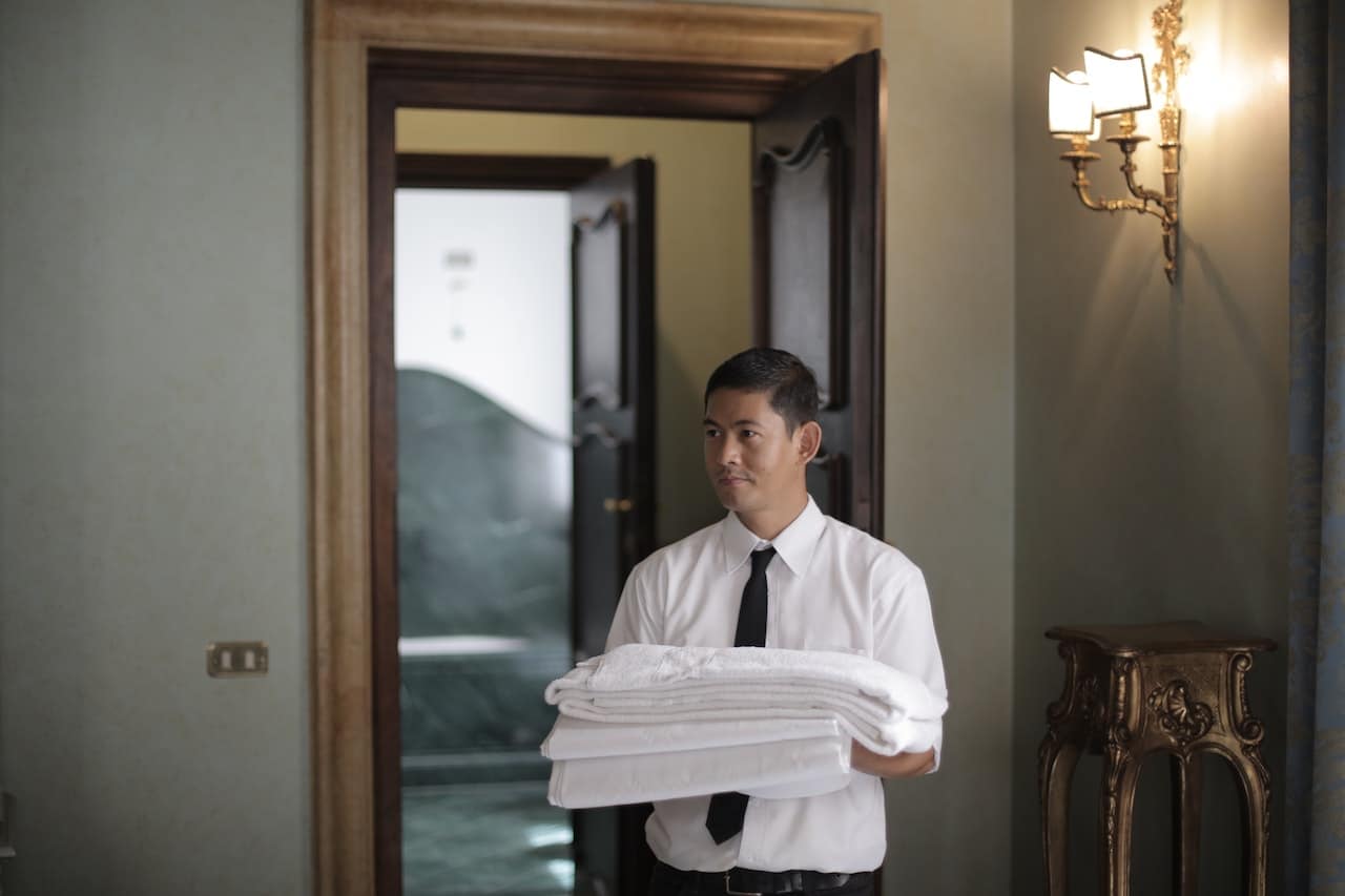 Hotel employee taking towels to a room