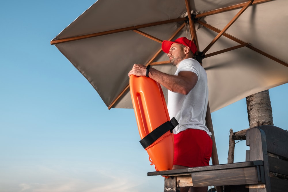 lifeguard with an orange rescue buoy