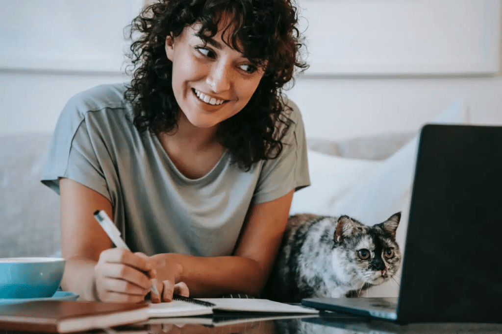 woman and cat looking at laptop screen
