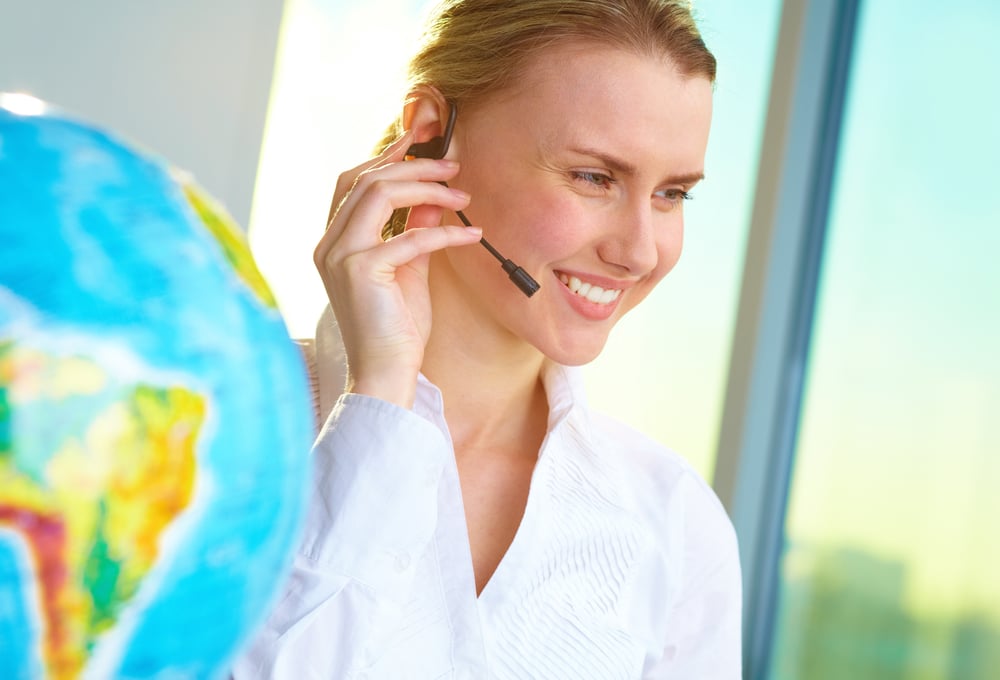 young blonde woman travel agent talking over a headset