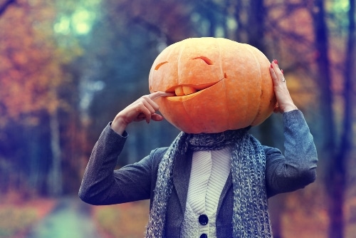 Man with pumpkin head costume on Halloween