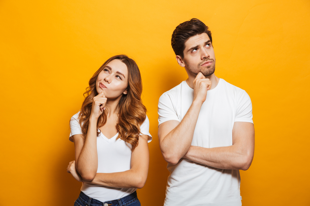 A man and a woman thinking in front of a yellow background