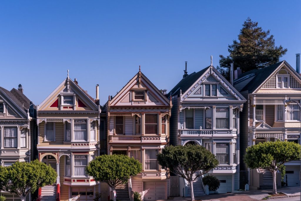picture-of-victorian-townhouses-lined-up-on-a-street-in-San-Francisco-with-blue-sky