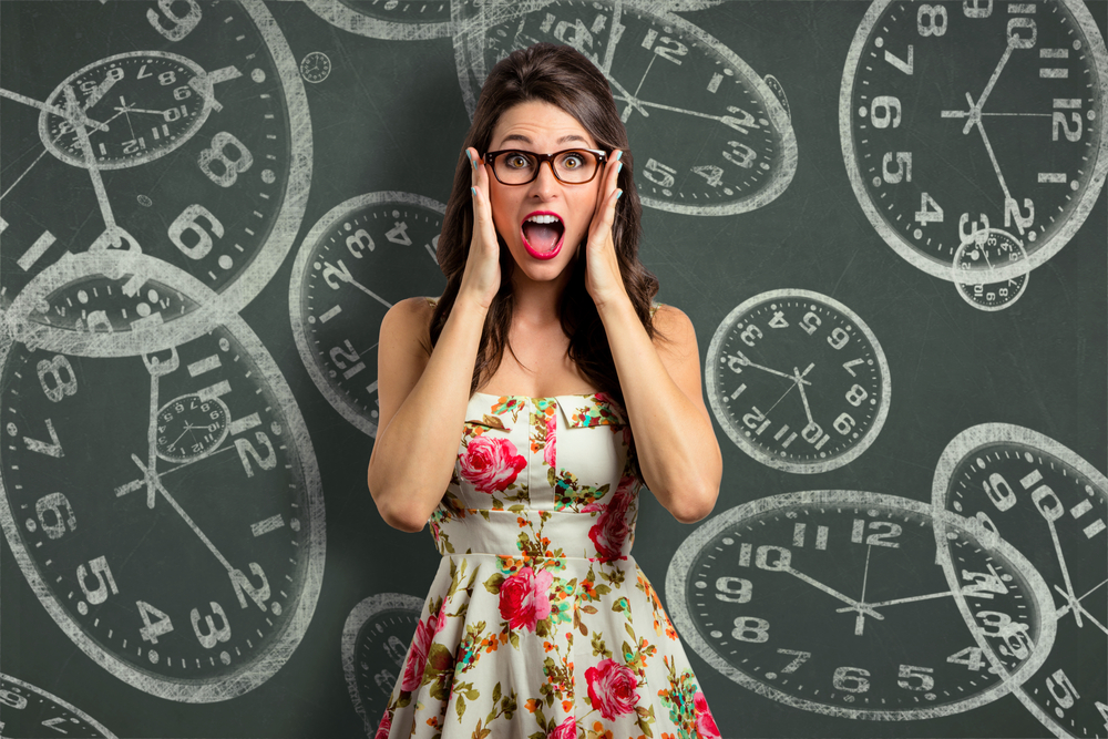 Shocked woman standing in front of drawings of clocks
