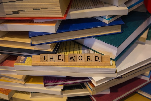 scrabble-rack-with-letters-spelling-out-the-phrase-quote-the-word-end-quote-stacked-on-top-of-books