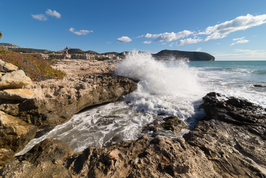 A wave crashing on a rocky shore