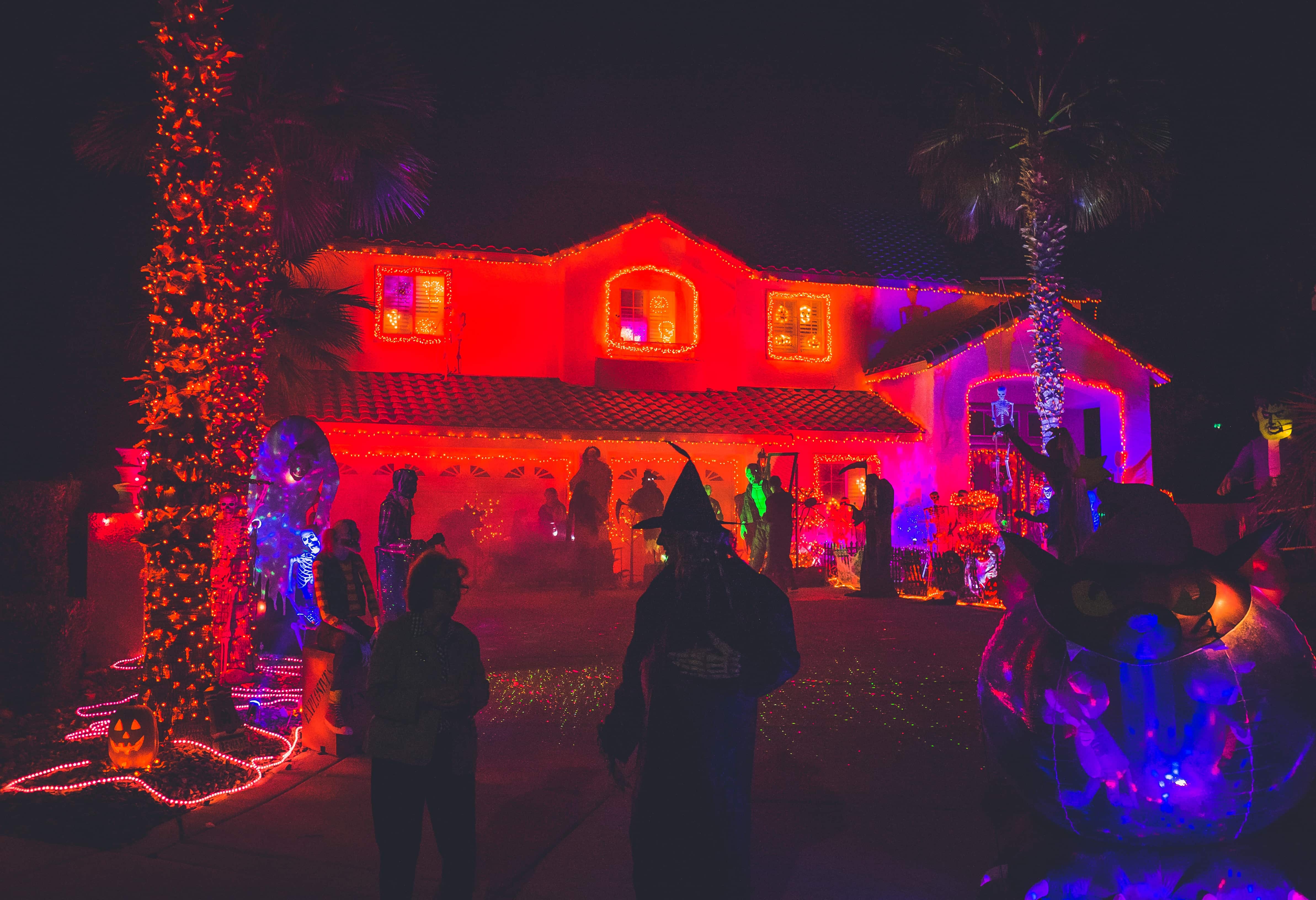 Trick-or-treaters in front of a decorated house on Halloween