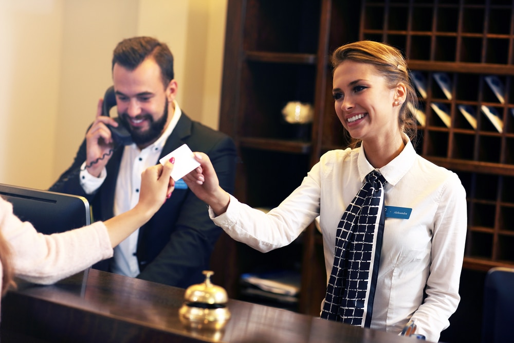 hotel receptionist giving key to guest