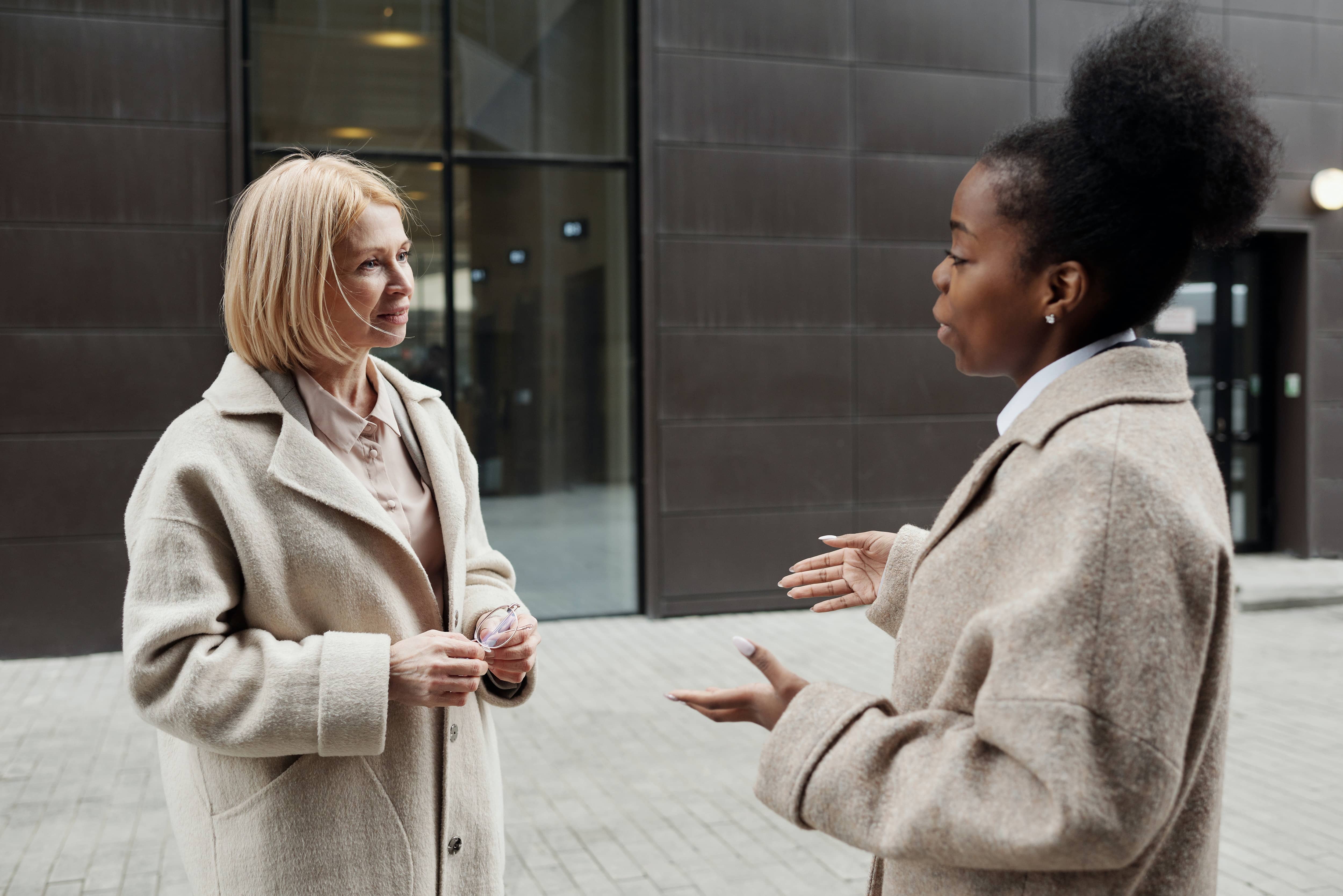 Two women talking outside an office building