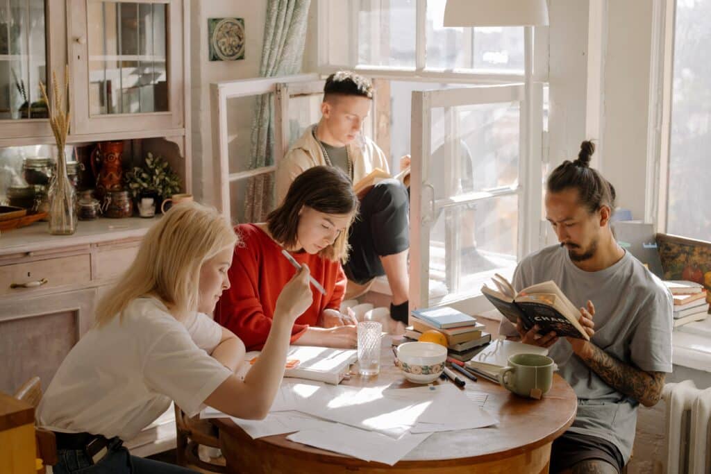 four-people-reading-and-writing-in-a-kitchen-silently-together