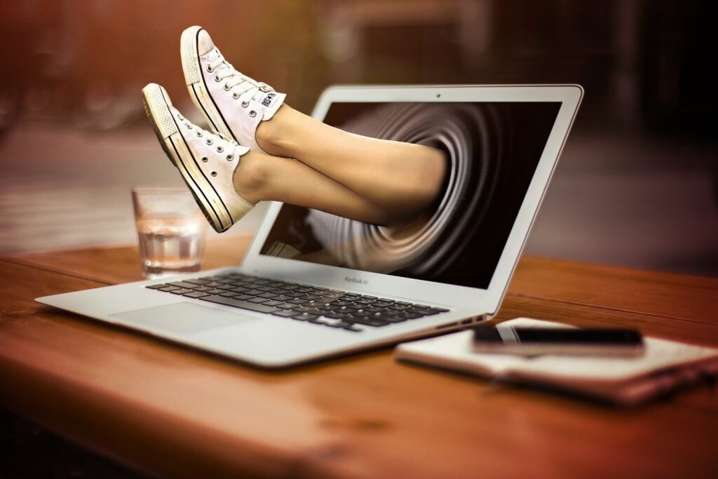 abstract-image-of-feet-wearing-whitish-canvas-shoes-sticking-out-of-macbook-air-screen