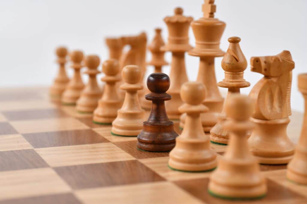chess-pieces-with-one-dark-brown-piece-and-the-rest-being-light-brown