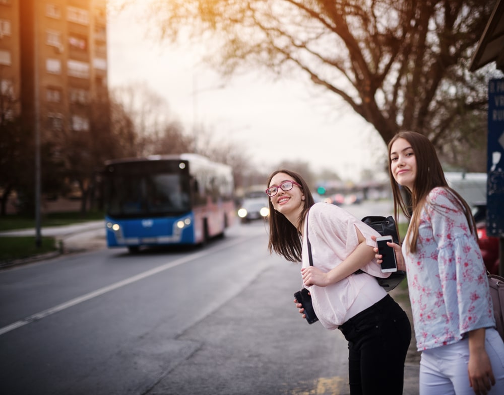 young women waiting at bus station