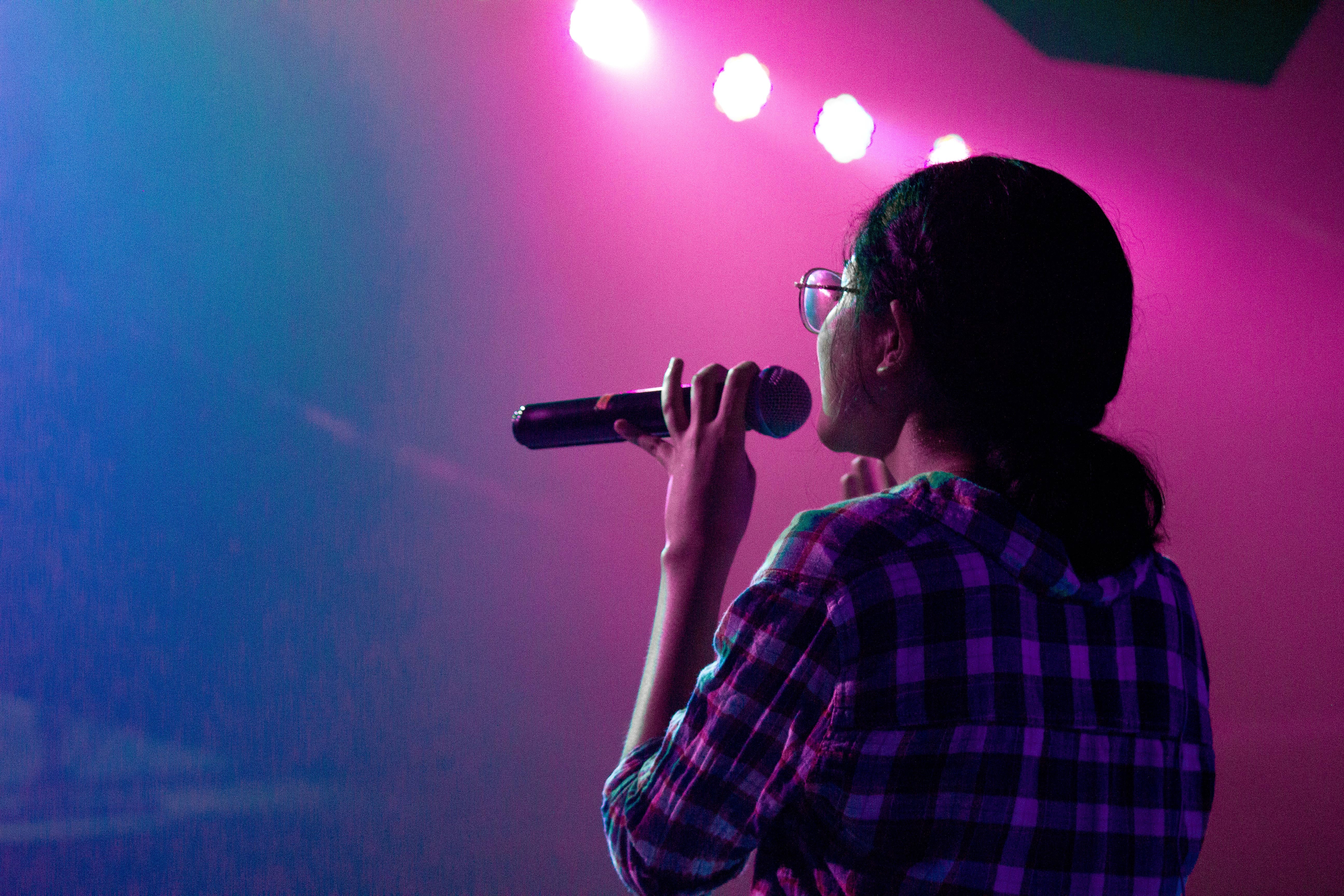 A woman singing karaoke on stage