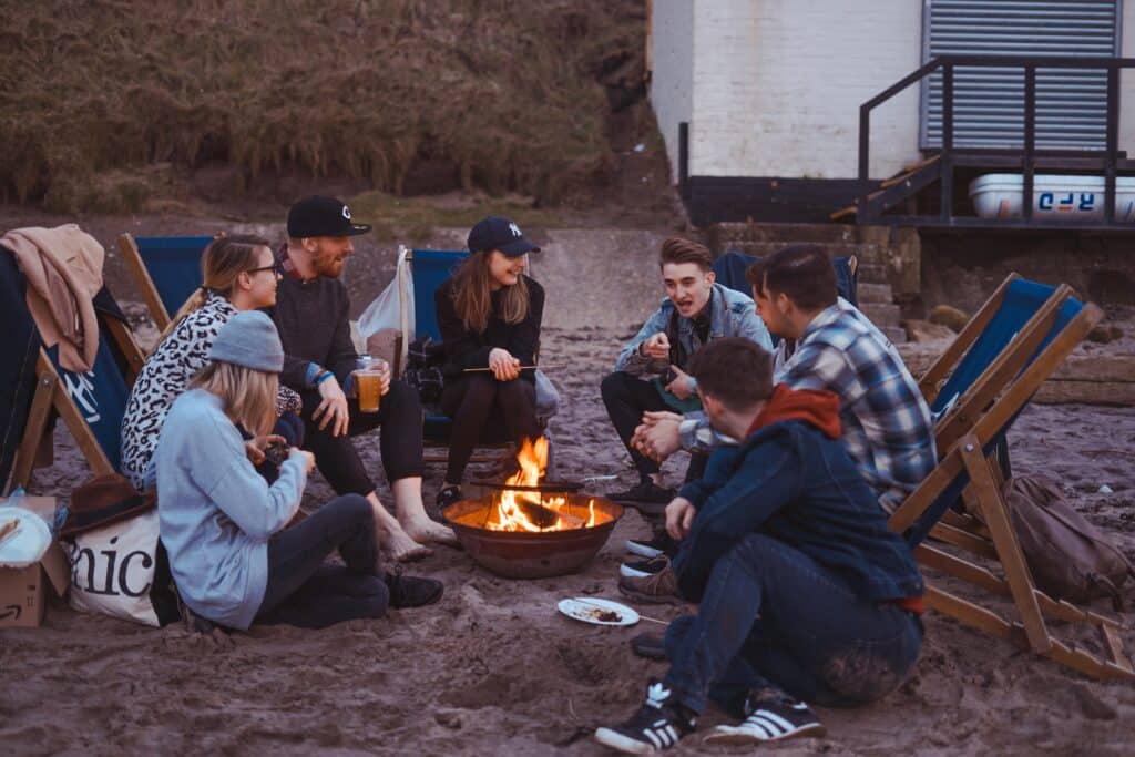 A group of friends sitting around a campfire and talking