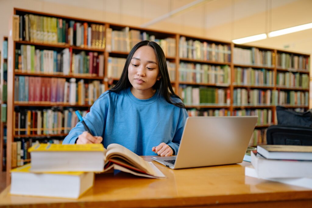 young-woman-studying-with-books-and-laptop