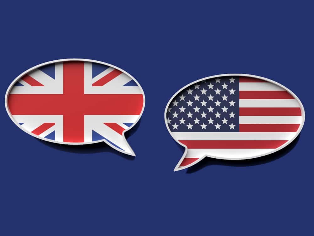 two-speech-bubbles-with-uk-and-us-flag-printed-on-them-against-navy-blue-background