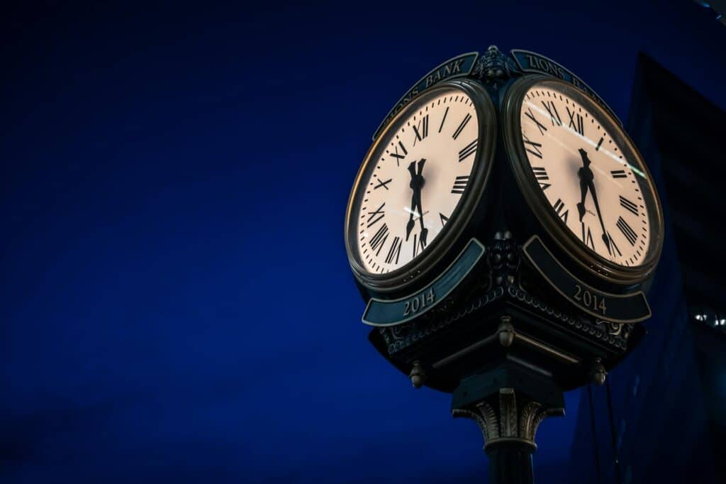 clock-with-two-faces-against-dark-blue-background