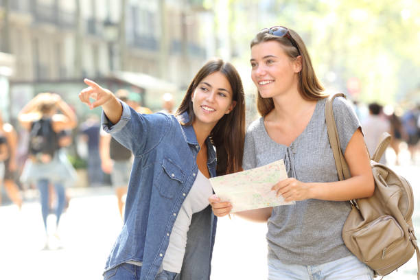 A helpful woman pointing a woman with a map in the right direction