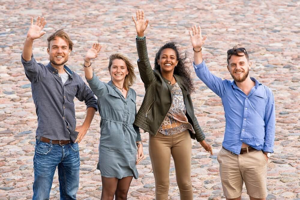A group of four people all waving