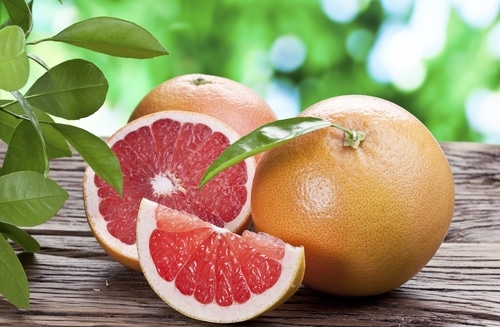photo-of-two-whole-grapefruit-and-one-sliced-grapefruit