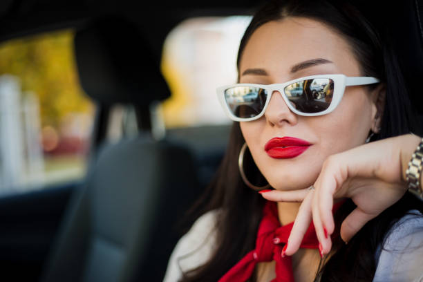 attractive-woman-wearing-shades-and-red-lipstick-while-inside-car