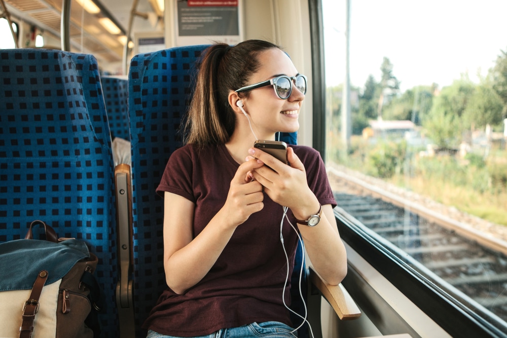 young girl listening to music while on the train
